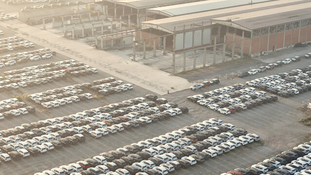 New cars and suvs awaiting shipment at a large factory parking lot, illustrating automotive logistics, import export, and global commerce
