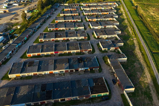 Aerial view of a large garage complex with rows of flat-roofed units and paved access paths in the late afternoon light in Kaisiadorys, Kaunas County, Lithuania.