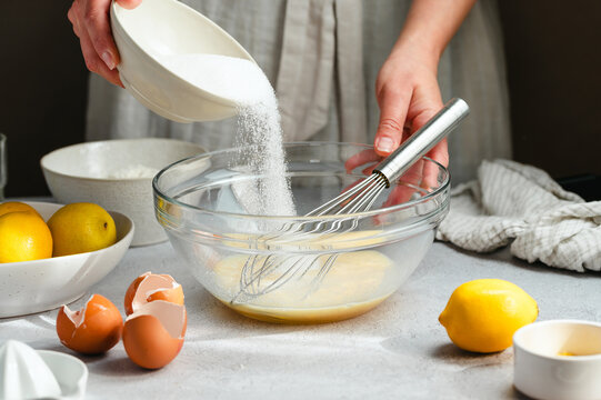 Adding sugar to lemon cake batter, process of cooking a dessert at home