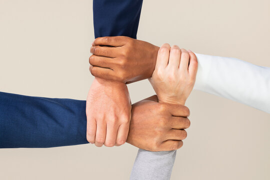 Diverse business team holding hands together for strength, startup motivation, and coworker unity