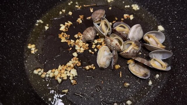 Vongole clams in a hot skillet, garlic butter sauce, sizzling seafood, Italian dish, aromatic.