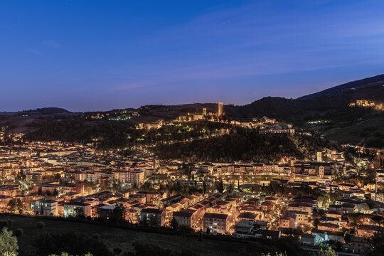 Aerial view of the illuminated historic town of San Severino Marche nestled in the hills of the Marche region at twilight San Severino Marche, Marche, Italy.
