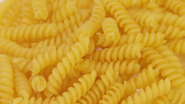 fond de p&acirc;tes fusilli crues en gros plan sur un plateau tournant