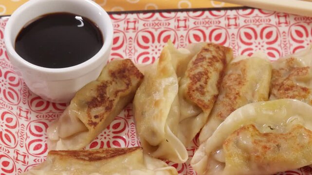 Gyozas grill&eacute;s, en gros plan, avec sauce soja	