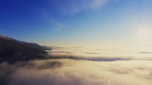 Wonderful view of extraordinary cloudy valley and bright orange sunset