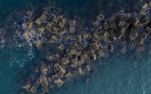 Aerial view of concrete tetrapods forming a breakwater in the deep blue sea of Raja Ampat, Southwest Papua, Indonesia.