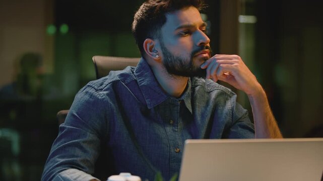 Thoughtful Arabian business man think come up with idea typing laptop at night office Indian businessman thinking planning pondering inspired agent working with computer finding solution at evening