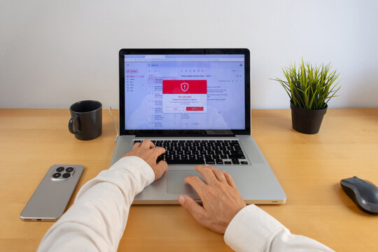 Laptop user checking email security warning and cybersecurity alert