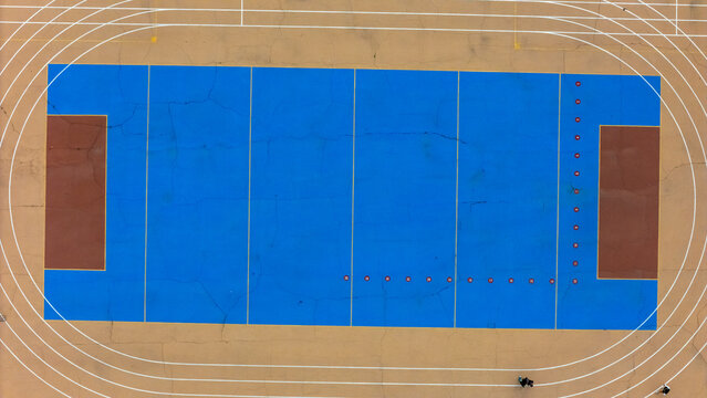View Park-Windsor Hills, California, United States - 16 September 2026: Aerial view of 54th Street Elementary School sports field with a blue court surface and running track.