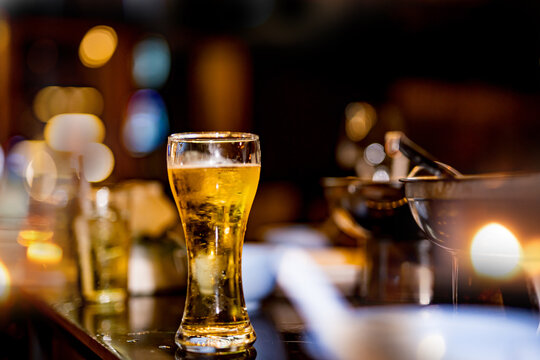 food and drink male friends are happy drinking beer and clinking glasses at a bar or pub.