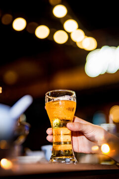 food and drink male friends are happy drinking beer and clinking glasses at a bar or pub.