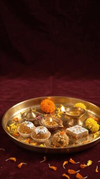 Template festival India vertikal menampilkan piring kuningan tradisional, ladoo, barfi, dan lampu minyak