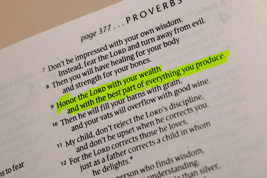 Close-up view of an open holy book with a bright neon green marker highlight on a specific scripture verse for daily devotion and faith study
