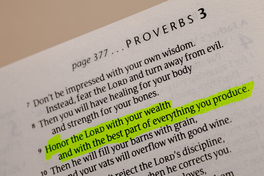 Close-up view of an open holy book page showing Proverbs chapter 3 with a bright green highlighter mark on scripture text for study use