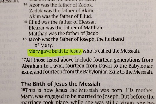 Close-up view of an open holy book page with highlighted text about the lineage and birth of Jesus Christ, traditional christianity faith