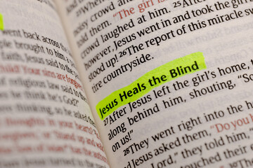 Fototapeta premium A close up view of an open holy book with text highlighted in vibrant green marker pen revealing spiritual scripture about faith and belief