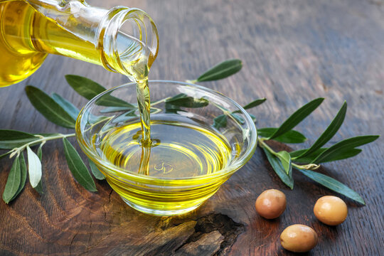 Organic olive oil pouring in a glass bowl	