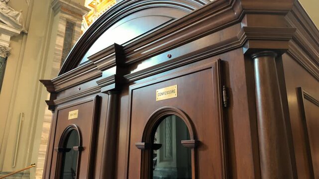 Traditional wooden confessional booth inside Catholic church, religious architecture close-up, video footage. High quality 4k footage