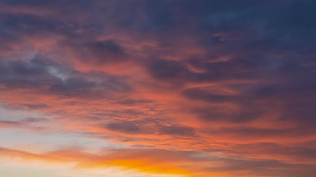 Experience the breathtaking spectacle of the vibrant sky as the sun descends, painting the heavens with fiery hues of orange and deep violet, evoking a sense of awe and wonder during this serene