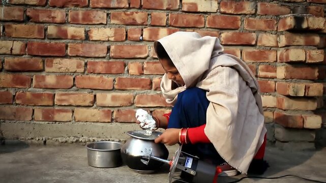 Rural Indian women extracting fresh white butter from buttermilk using traditional bilona method which is traditional Vedic process of making pure desi ghee by churning curd instead of directly using 