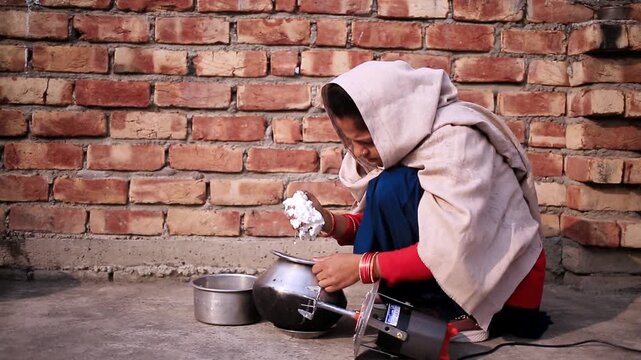 Rural Indian women extracting fresh white butter from buttermilk using traditional bilona method which is traditional Vedic process of making pure desi ghee by churning curd instead of directly using 