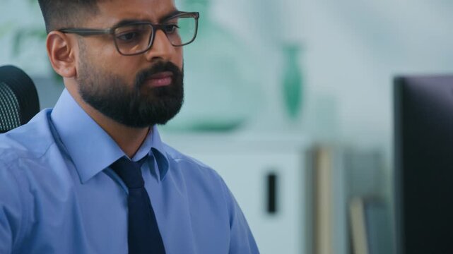 Concentrated Muslim business man Arabian male working with documents and computer in office ethnic worker Indian businessman male productive executive specialist work with desktop and papers stats
