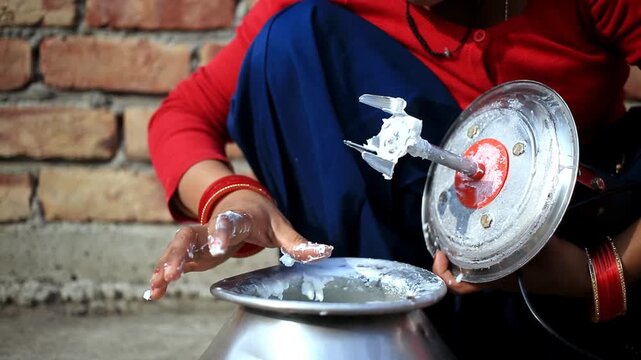 Human hand extracting fresh white butter from buttermilk using traditional bilona method which is traditional Vedic process of making pure desi ghee by churning curd instead of directly using cream at