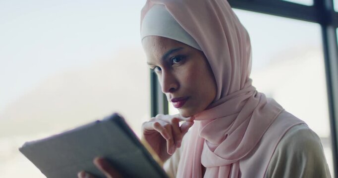 20s female wearing pink scarf being prompted by screen and scrolling fabric case tablet by window