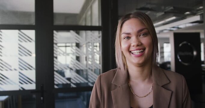 African American woman laughing reacting to offcamera cue at office glass divider
