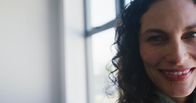 Adult African American woman holding gaze in closeup smiling by pane window with labret, copy space
