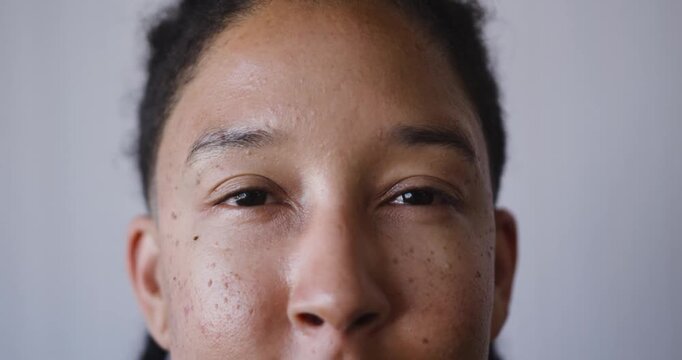 Nonbinary adult opening eyes slowly in studio, reacting to soft light and looking toward camera