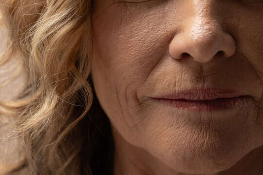 Senior female showing lower face close-up in studio, highlighting skin texture and hair