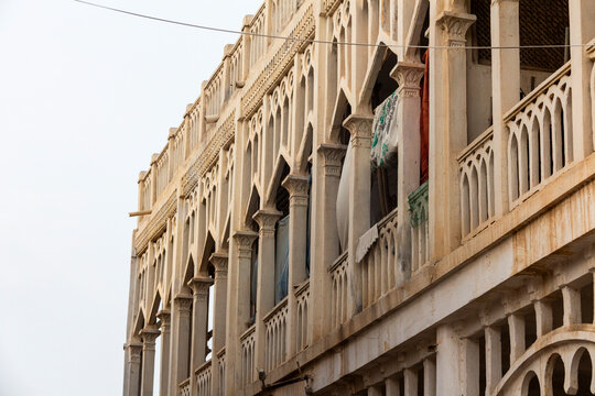 Laundry hangs from the balconies of a historic Ottoman architecture building with carved stone columns, Northern Red Sea, Massawa, Eritrea