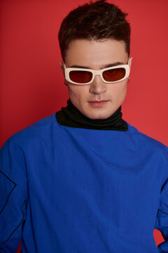 Young handsome man showcases chic style with bold color and trendy sunglasses