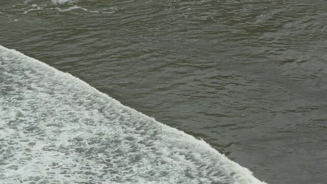 High Angle Shot of Single Ocean Wave Rolling and Breaking on Water Surface