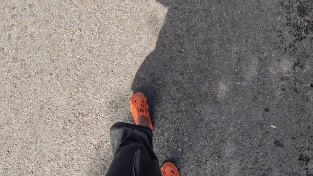 Close-up person walking road, capturing footsteps movement. day, child, daily, active, city, urban, rustic, street walking, walking alone, fashion, casual, asphalt, ground, travel, light, sport
