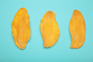 Obraz premium Slices of dried mango on blue background.