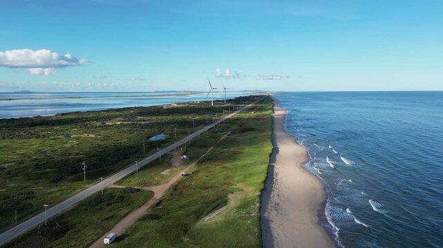 Aerial View of Coastal Spit with Road Beach and Wind Turbines