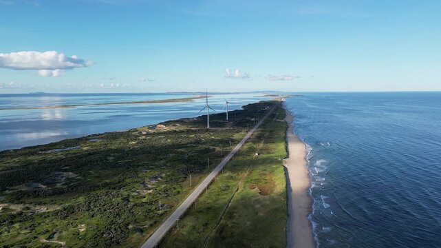 Aerial View of Coastal Spit with Beach Road and Wind Turbines
