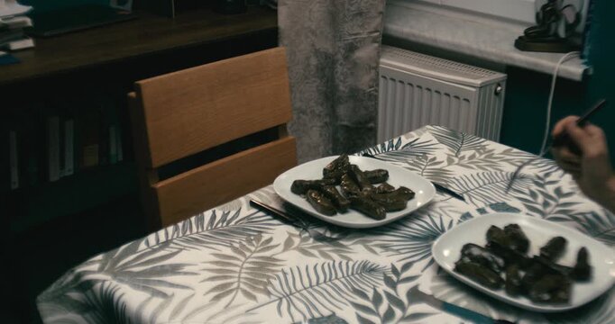 Cinematic medium shot of empty chair at table with dolmas in room