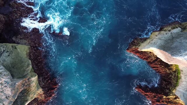 Top Down Rising Drone Shot of Narrow Ocean Channel Between Sea Cliffs