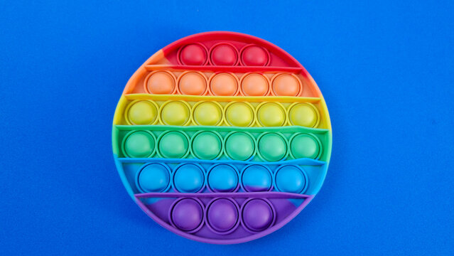Rainbow Pop It Fidget Toy on Blue Background