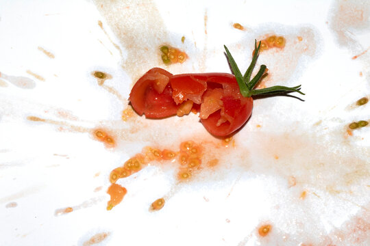 A squashed splattered and crushed broken fresh tomato with seeds