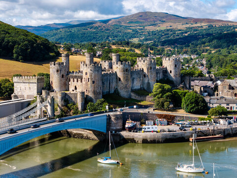 Conwy Castle and historic bridges spanning River Conwy, North Wales, medieval stone fortress rising above the estuary with mountains in background