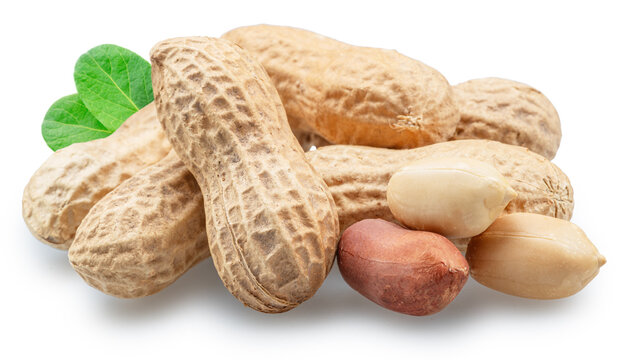 Unshelled and shelled peanuts with green peanut leaves isolated on a white background.
