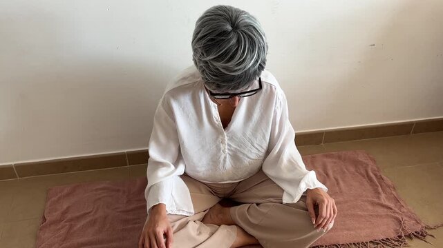 Mujer haciendo ejercicios de respiraci&oacute;n para menopausia en plano corto