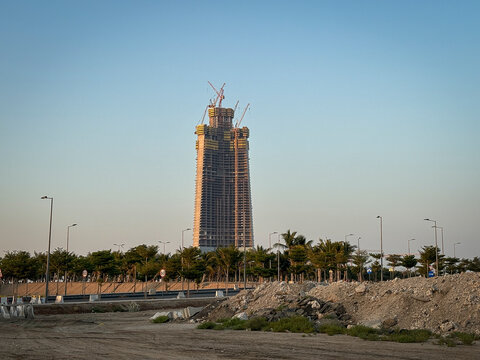 A pile of rubble lies beside the road leading toward the distant Kingdom Tower, Makkah, Jeddah, Saudi Arabia