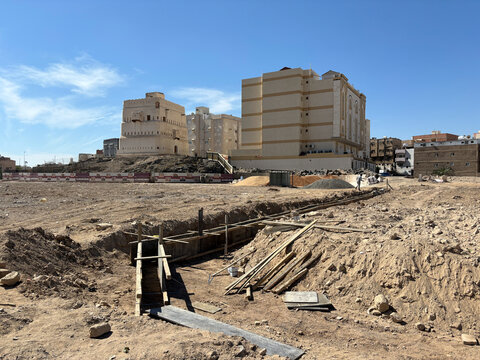 Excavated trenches open before old and new buildings at a construction site, Al Madinah Province, Madinah, Saudi Arabia