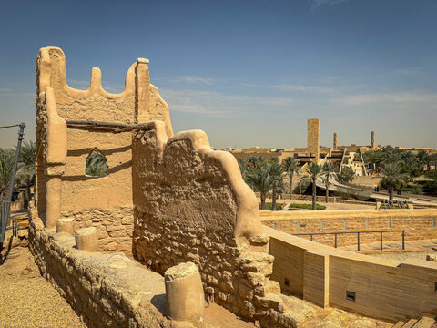 A crenellated mud brick tower rises above the modern skyline of Diriyah, Riyadh, Riyadh, Saudi Arabia