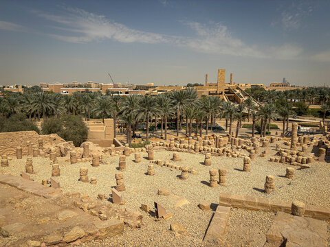 Excavated stone ruins overlook a dense palm grove on the edge of Diriyah, Riyadh, Riyadh, Saudi Arabia